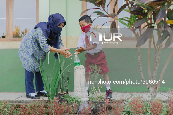 A teacher teach a student to wash his hands at Candirejo Elementary School, Semarang Regency, Central Java, Indonesia, on September 1, 2020....