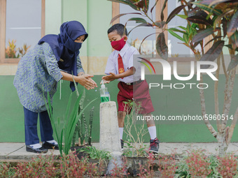 A teacher teach a student to wash his hands at Candirejo Elementary School, Semarang Regency, Central Java, Indonesia, on September 1, 2020....