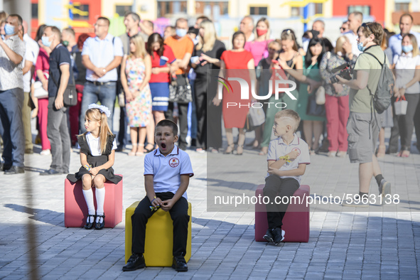 First graders sit on separate poufs for social distancing during a ceremony to mark the start of the new school year, amid the outbreak of t...