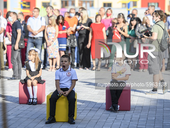 First graders sit on separate poufs for social distancing during a ceremony to mark the start of the new school year, amid the outbreak of t...