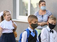 First graders wear protective face masks during a ceremony to mark the start of the new school year, amid the outbreak of the coronavirus di...