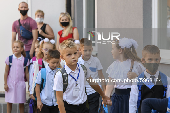 First graders wear protective face masks during a ceremony to mark the start of the new school year, amid the outbreak of the coronavirus di...