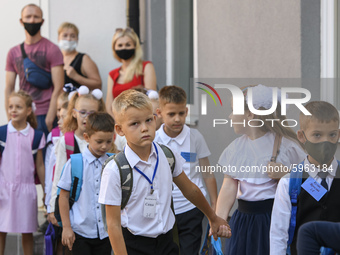 First graders wear protective face masks during a ceremony to mark the start of the new school year, amid the outbreak of the coronavirus di...