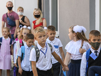 First graders wear protective face masks during a ceremony to mark the start of the new school year, amid the outbreak of the coronavirus di...