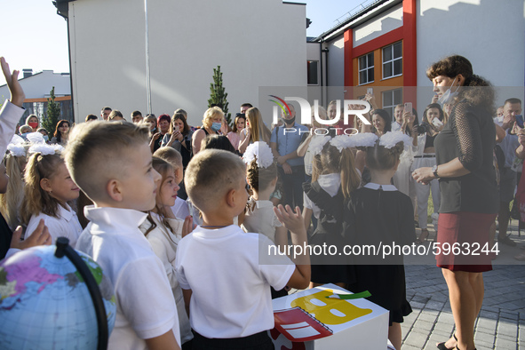 Parents and first graders wear protective face masks during a ceremony to mark the start of the new school year, amid the outbreak of the co...