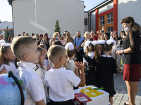 Parents and first graders wear protective face masks during a ceremony to mark the start of the new school year, amid the outbreak of the co...