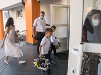 Parents and first graders wear protective face masks during a ceremony to mark the start of the new school year, amid the outbreak of the co...