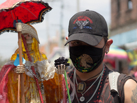 Devotees to the Santa Muerte attend her altar in the Bravo de Tepito neighborhood with face masks because the presence of Covid-19 does not...