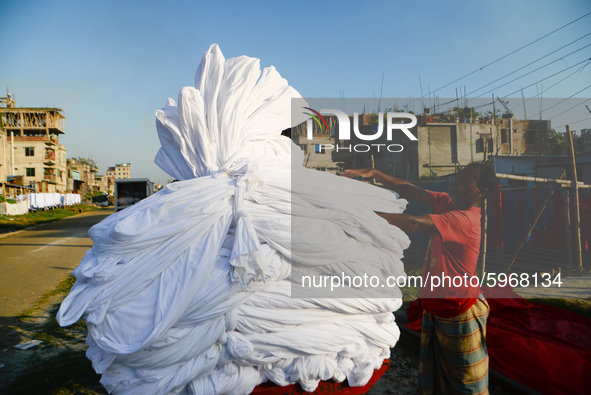 A worker dry fabric under the sun after dyeing them in a factory in Narayanganj, Bangladesh on September 03, 2020. 