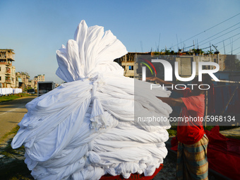 A worker dry fabric under the sun after dyeing them in a factory in Narayanganj, Bangladesh on September 03, 2020. (