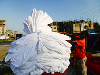 A worker dry fabric under the sun after dyeing them in a factory in Narayanganj, Bangladesh on September 03, 2020. (