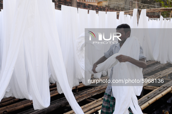 A worker dry fabric under the sun after dyeing them in a factory in Narayanganj, Bangladesh on September 03, 2020. 