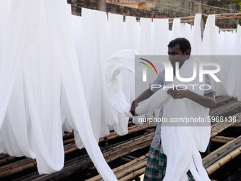 A worker dry fabric under the sun after dyeing them in a factory in Narayanganj, Bangladesh on September 03, 2020. (