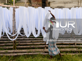 A worker dry fabric under the sun after dyeing them in a factory in Narayanganj, Bangladesh on September 03, 2020. (