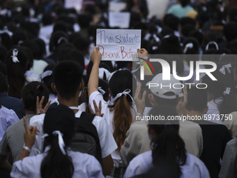 Thai students hold placards as they show support for the student-led democracy movement in front of the Ministry of Education, in Bangkok, T...