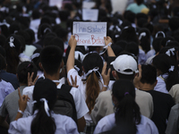 Thai students hold placards as they show support for the student-led democracy movement in front of the Ministry of Education, in Bangkok, T...