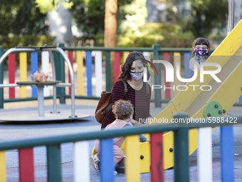 A woman with a facemask is playing with her daughter on a street playground during the first day of school on September 10, 2020 in Granada,...