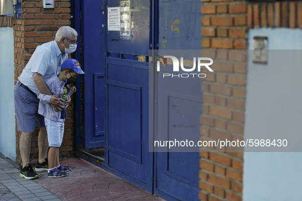 An old man and his grandchild wearing facemasks during the first day of school on September 10, 2020 in Granada, Spain.  