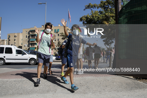 Two children waves and run with facemasks during the first day of school on September 10, 2020 in Granada, Spain.  