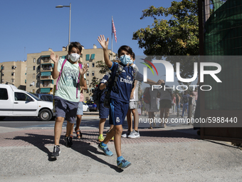 Two children waves and run with facemasks during the first day of school on September 10, 2020 in Granada, Spain.  (