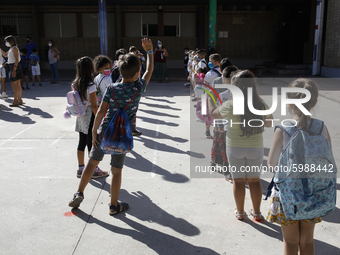 Many children with facemasks wait in some long queues to disinfect their hands during the first day of school on September 10, 2020 in Grana...