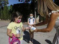 A teacher cleans a student's hands with a hand sanitiser before entering to class during the first day of school on September 10, 2020 in Gr...