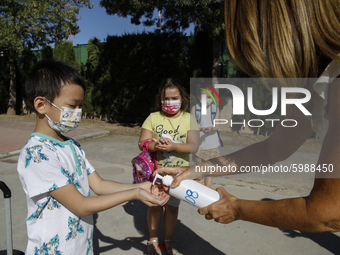 A teacher cleans a student's hands with a hand sanitiser before entering to class during the first day of school on September 10, 2020 in Gr...