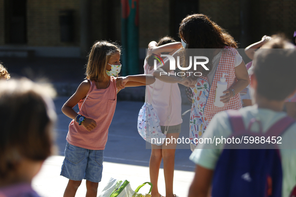 A teacher and a student bumping elbows before entering to class during the first day of school on September 10, 2020 in Granada, Spain.  