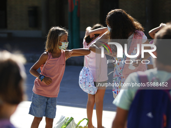 A teacher and a student bumping elbows before entering to class during the first day of school on September 10, 2020 in Granada, Spain.  (