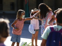 A teacher and a student bumping elbows before entering to class during the first day of school on September 10, 2020 in Granada, Spain.  (