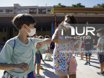 A teacher and a student bumping elbows before entering to class during the first day of school on September 10, 2020 in Granada, Spain.  (