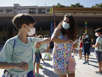 A teacher and a student bumping elbows before entering to class during the first day of school on September 10, 2020 in Granada, Spain.  (