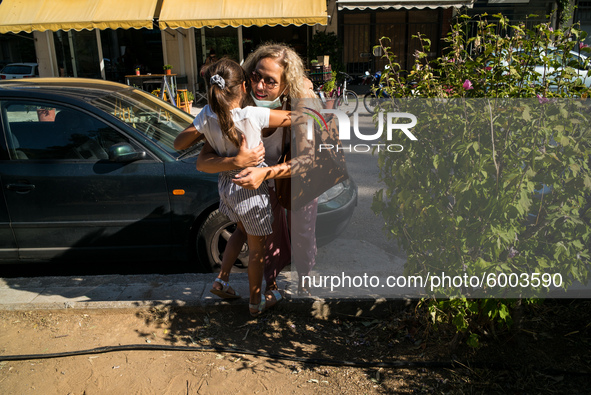 A mother hugs her daughter after finishing the first day in school, on September 14, 2020, Nea Ionia, Athens  