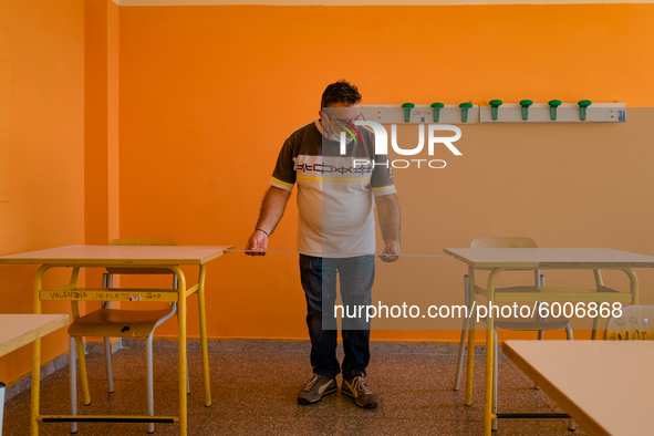 A janitor taking the measurement (1 meter) for the spacing of the classroom desks in the Don Tonino Bello High School in Molfetta on 16th Se...