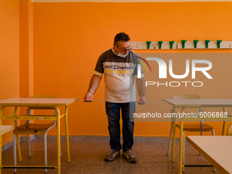 A janitor taking the measurement (1 meter) for the spacing of the classroom desks in the Don Tonino Bello High School in Molfetta on 16th Se...