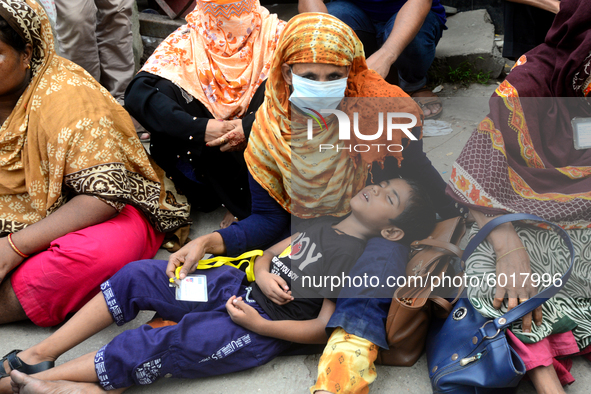 A child sleeping in his mother's lap during garments workers of Dragon Group stage a demonstration in front of Department of Labor building...