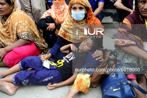 A child sleeping in his mother's lap during garments workers of Dragon Group stage a demonstration in front of Department of Labor building...