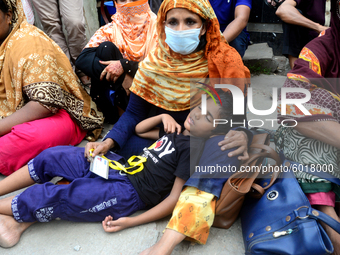 A child sleeping in his mother's lap during garments workers of Dragon Group stage a demonstration in front of Department of Labor building...