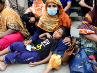 A child sleeping in his mother's lap during garments workers of Dragon Group stage a demonstration in front of Department of Labor building...