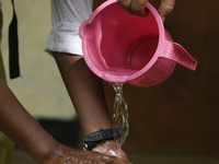 Teacher helps a student washing hands before attend class, in Guwahati, Assam, India on September 21, 2020 as schools reopened after more th...