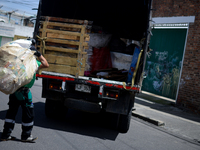 A worker loads the recycled material into the truck during a working day in the town of San Cristóbal, in Bogota, Colombia on September 9, 2...