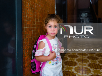 A little girl waiting to go to school, on the first day, waits for her mother down at the front door, in Molfetta, Italy, on 24 September 20...