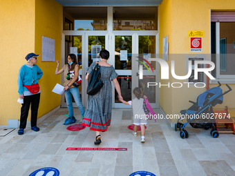 A little girl enters kindergarten with her mother on the first day of school in Molfetta on 24 September 2020.
The return to school for chi...