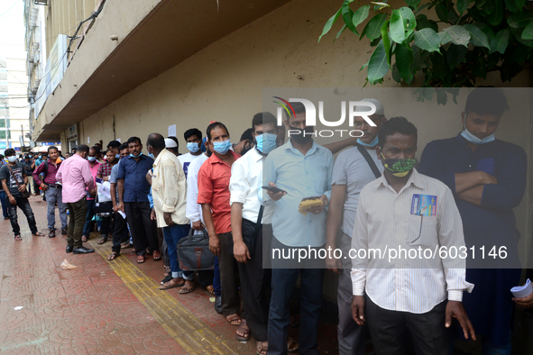 Bangladeshi migrant workers who work in Saudi Arabia gather in front of the Biman Bangladesh Airlines office to collect air tickets to go ba...