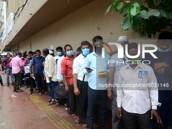 Bangladeshi migrant workers who work in Saudi Arabia gather in front of the Biman Bangladesh Airlines office to collect air tickets to go ba...