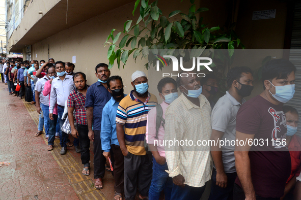 Bangladeshi migrant workers who work in Saudi Arabia gather in front of the Biman Bangladesh Airlines office to collect air tickets to go ba...