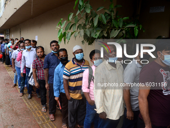 Bangladeshi migrant workers who work in Saudi Arabia gather in front of the Biman Bangladesh Airlines office to collect air tickets to go ba...