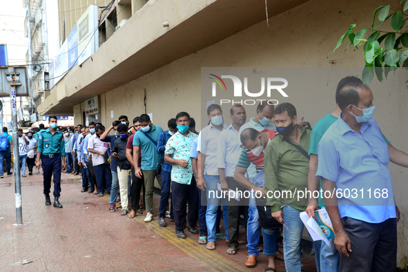 Bangladeshi migrant workers who work in Saudi Arabia gather in front of the Biman Bangladesh Airlines office to collect air tickets to go ba...