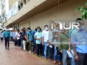 Bangladeshi migrant workers who work in Saudi Arabia gather in front of the Biman Bangladesh Airlines office to collect air tickets to go ba...