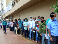 Bangladeshi migrant workers who work in Saudi Arabia gather in front of the Biman Bangladesh Airlines office to collect air tickets to go ba...